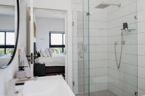 a bathroom with a shower and a mirror at Uitwaaien Beach Cottage in Pearly Beach