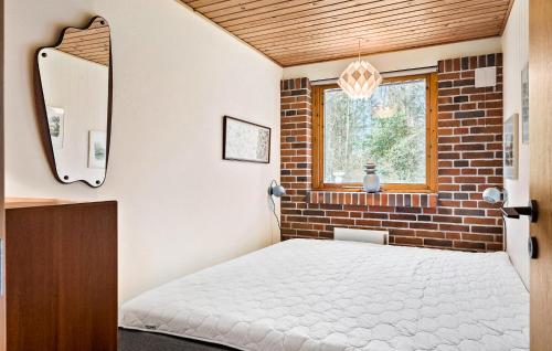 a bedroom with a bed and a brick wall at 3 Bedroom Nice Home In Spttrup in Spottrup
