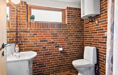 a brick bathroom with a toilet and a sink at 3 Bedroom Nice Home In Spttrup in Spottrup