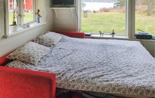 a bed in a room with two pillows and a window at Gorgeous Home In Strmstad With House Sea View in Strömstad