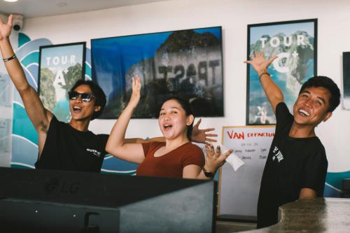 een groep mensen met hun handen in de lucht bij Outpost Beach Hostel in El Nido