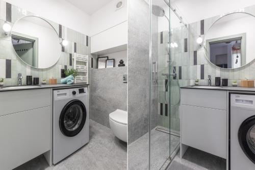 a bathroom with a washing machine and a shower at SuperApart Orla 5 in Warsaw