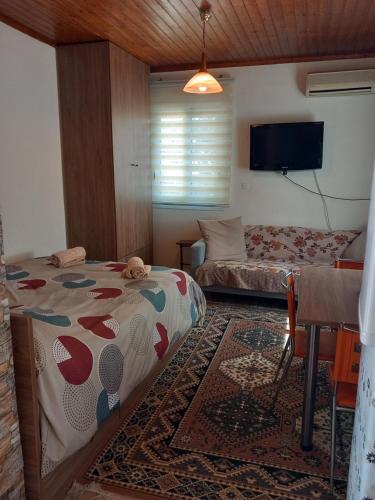 a bedroom with a bed and a couch and a tv at Casa Fare in Kalamata