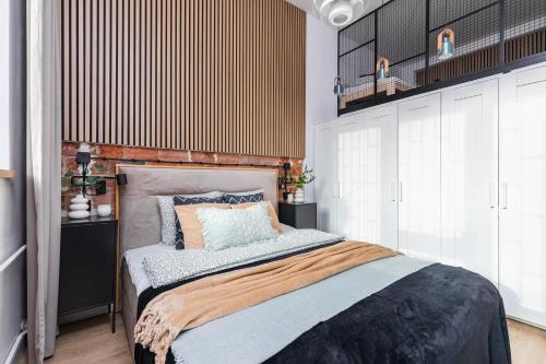 a bedroom with a bed with a wooden headboard at SuperApart Orla 5 in Warsaw