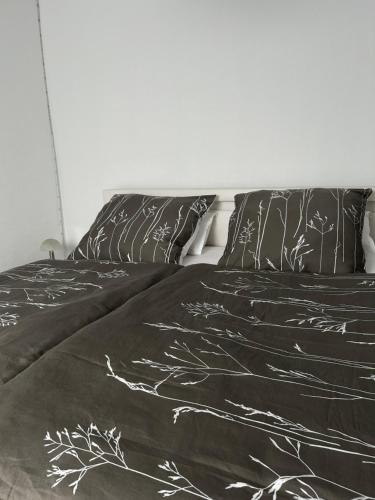 a bed with black and white sheets and pillows at Ferienwohnung Zur Wildkatze in Hallenberg