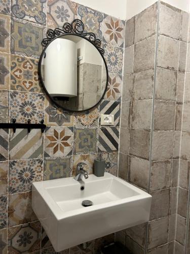 een badkamer met een wastafel en een spiegel bij Apartman Arioso in Piran