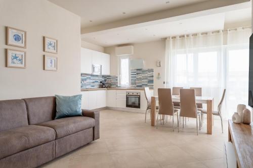 een woonkamer met een bank en een tafel met stoelen bij La casa del sole a 50 m dal mare in Lido di Camaiore