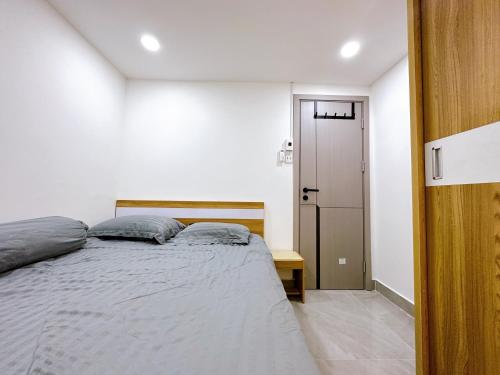 1 dormitorio con 1 cama grande y puerta en Alley Homestay Sai Gon, en Ho Chi Minh
