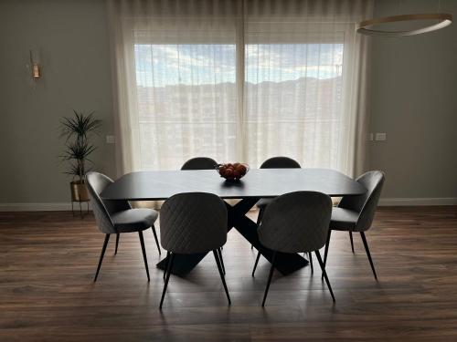 mesa de comedor y sillas en una habitación con ventana en Luxury Penthouse with Terrace and Private Parking in Tirana, en Tirana