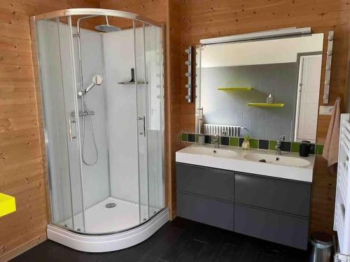 uma casa de banho com um chuveiro, 2 lavatórios e um espelho. em Rugles Cocooning em Rugles