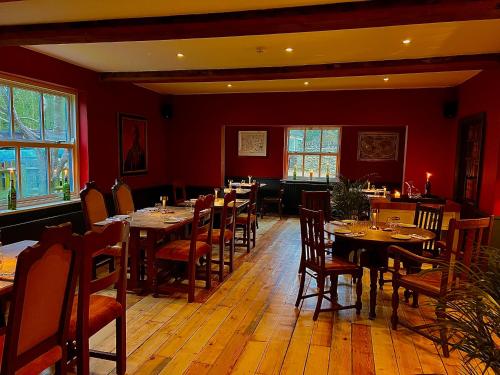 a restaurant with tables and chairs and red walls at Five Alls in Lechlade