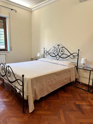 een slaapkamer met een groot bed en een houten vloer bij VerdeMareVilla in Avola