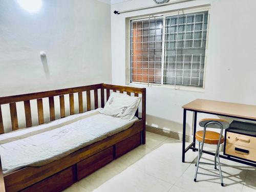 1 dormitorio con cama, escritorio y mesa en Shanthi Home Stay en Puttaparthi