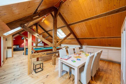 a dining room with a table and chairs in a attic at Les Frangines in Saint-Hubert