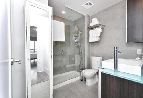 a bathroom with a shower and a toilet and a sink at Metropolis Loft - CN Tower in Toronto