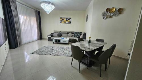 a living room with a table and a couch at Nice 2 bedroom Al Marjan island near the beach in Ras al Khaimah