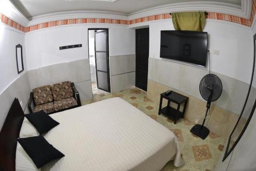 a bedroom with a bed and a flat screen tv at La Hermosa Hotel in Buga