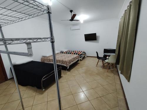 1 dormitorio con 2 literas y escritorio en Pousada Indi en Ribeirão Preto