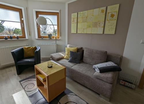 a living room with a couch and a chair at Ferienwohnung Schlossblick in Eisfeld
