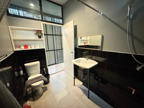 a bathroom with a toilet and a sink and a mirror at Ren pool villa 清迈3卧泳池别墅 in Chiang Mai