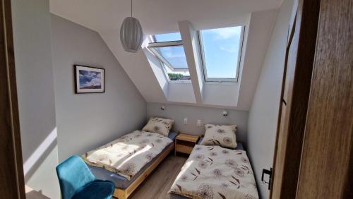 a small room with two beds and a window at Letnia in Wilkasy
