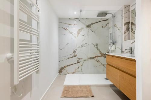 a white bathroom with a marble wall at {St Fée sur les toits} * plein centre Marseille * Clim in Marseille