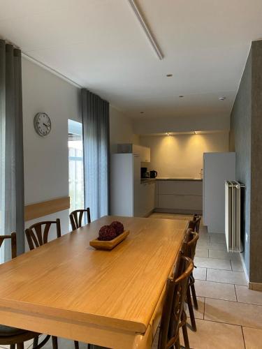a kitchen and dining room with a wooden table and chairs at d'Uyterwaerde in Leut