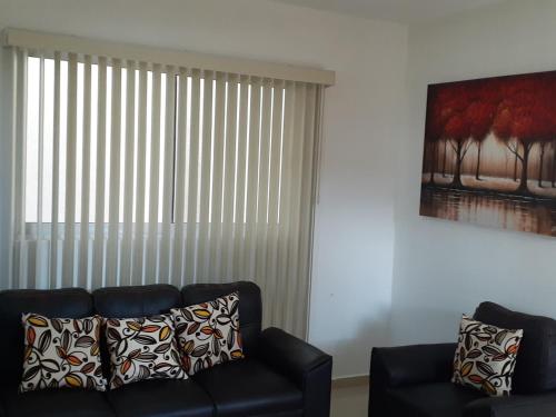 a living room with a couch and a window with vertical blinds at Casa Amealco in Amealco