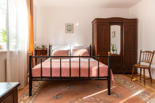 een slaapkamer met een bed, een stoel en een spiegel bij Pink Rose Suite in Józefów