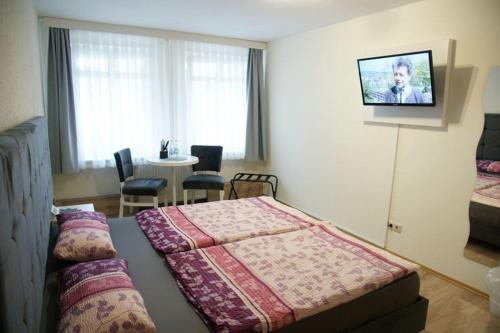 1 dormitorio con 1 cama y 1 mesa con sillas en Das Sofa Restaurant-Pension-Spätkauf, en Greifswald