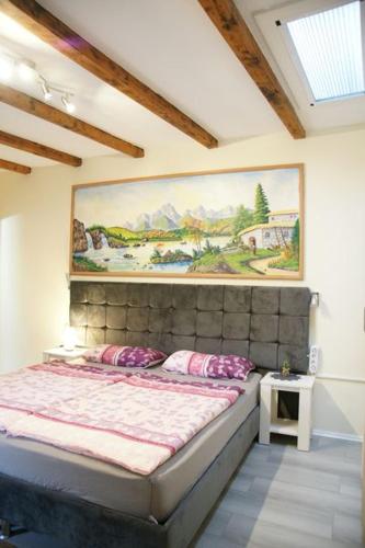 a bedroom with a bed with a painting on the wall at Das Sofa Restaurant-Hotel-Spätkauf in Greifswald