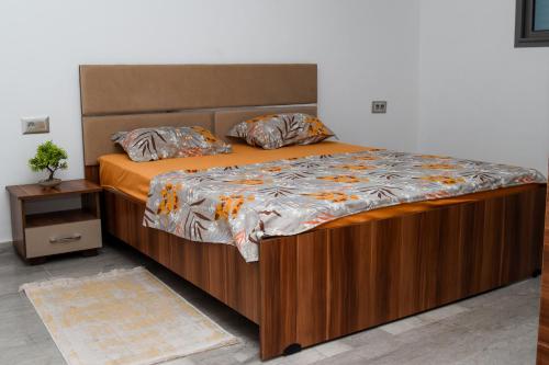 a large bed with a wooden frame in a bedroom at residence mami in Gabès
