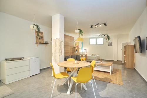a kitchen and dining room with a table and yellow chairs at Ran's BIG Artistic Studio in Tel Aviv