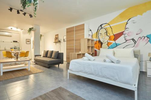 a bedroom with a bed with a painting on the wall at Ran's BIG Artistic Studio in Tel Aviv