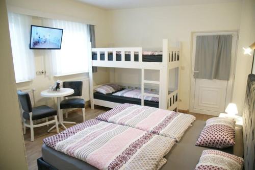 a bedroom with two bunk beds and a desk at Das Sofa Restaurant-Hotel-Spätkauf in Greifswald