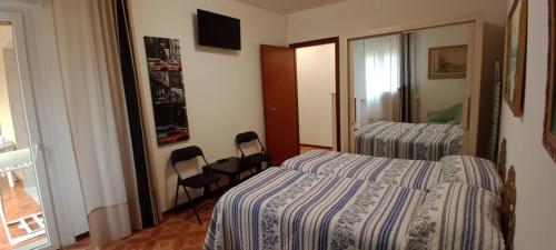 a hotel room with two beds and two chairs at Appartamento Giusy in Ventimiglia