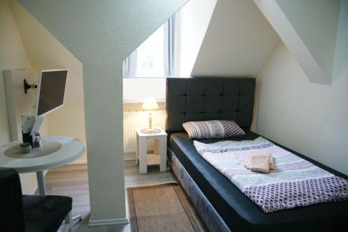 a bedroom with a bed and a table and a window at Das Sofa Restaurant-Hotel-Spätkauf in Greifswald