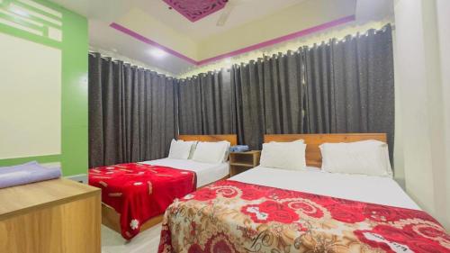twee bedden in een kamer met zwarte gordijnen bij Hotel Shah Nibash Panthapath in Dhaka