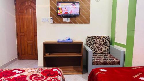 een kamer met een bed, een bureau en een televisie bij Hotel Shah Nibash Panthapath in Dhaka