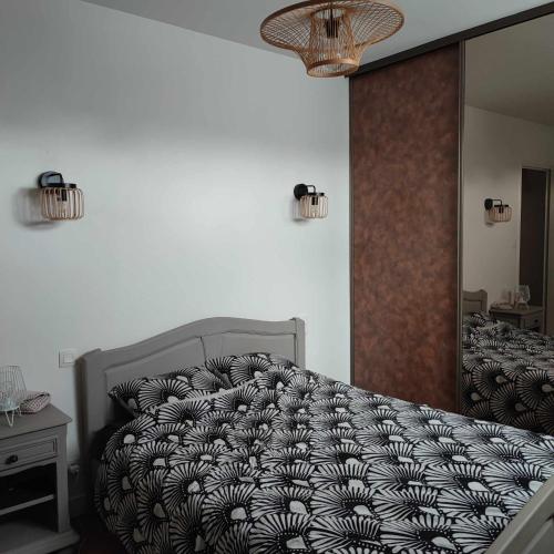 une chambre avec un lit avec une couette noire et blanche dans l'établissement location en Bretagne, à Néant-sur-Yvel