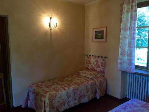 a bedroom with a bed and a light on the wall at Le 5 Frecce in Cavour