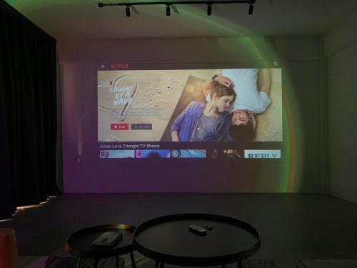 um quarto com um grande ecrã com uma mesa e uma televisão em City Center w/ Home Cinema @The 5000 studio em Kuala Terengganu