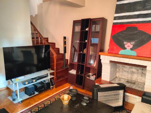 a living room with a television and a fireplace at Katrin's House in Katerini