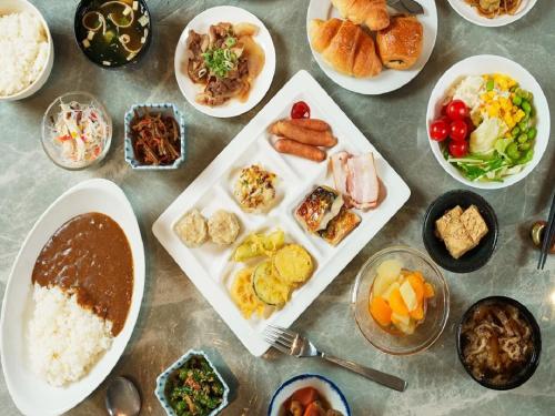 a table topped with plates of food and bowls of food at APA Hotel Saga Ekimae Chuo in Saga