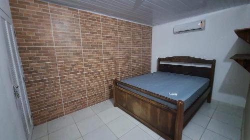 Habitación pequeña con cama con pared de ladrillo en casa do fred, en Guarujá