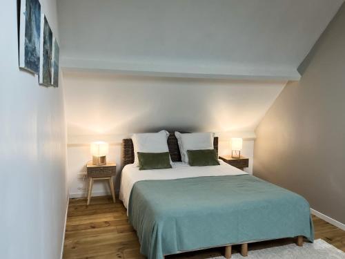 サン・ヴァレリー・シュル・ソンムにあるLa Villa Saint Valのベッドルーム1室(大型ベッド1台、ランプ2つ付)