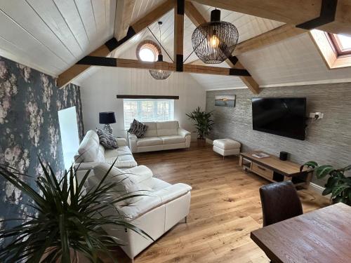 a living room with a white couch and a tv at Colemans Retreat in Porchfield