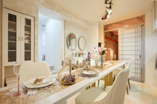 a dining room with a long table and white chairs at Papillon Paradis Higashi-Shinjuku in Tokyo