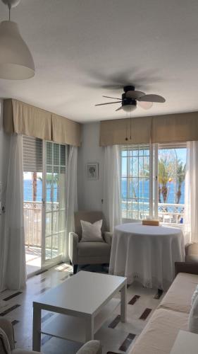 una sala de estar con una mesa y un sofá en Apartamento en Primera Linea, en La Herradura