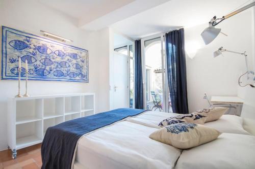 a bedroom with a large white bed and a window at Charming apartment w/courtyard in historical house in Lugano